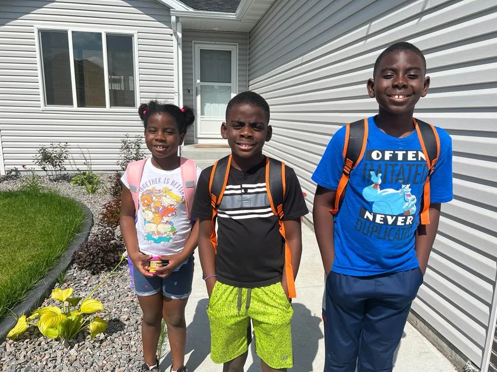 Three children ready for school with new backpacks