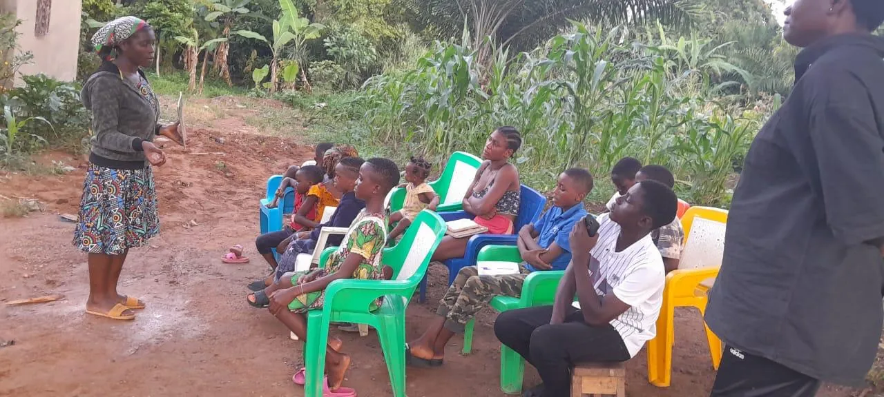 Children listening to an evening Bible lesson outdoors