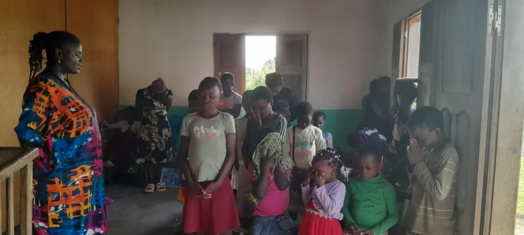 Children praying together in a Bible club meeting room