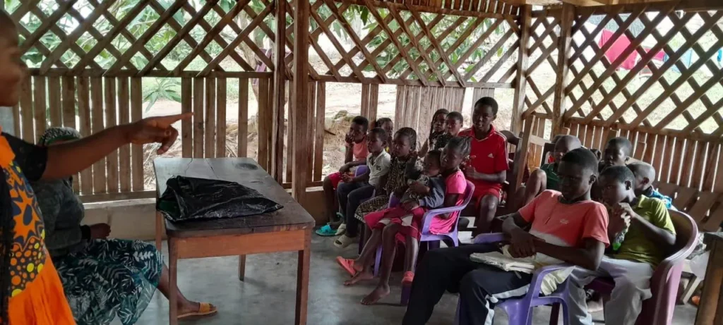 A teacher leading children in an open-air Bible class