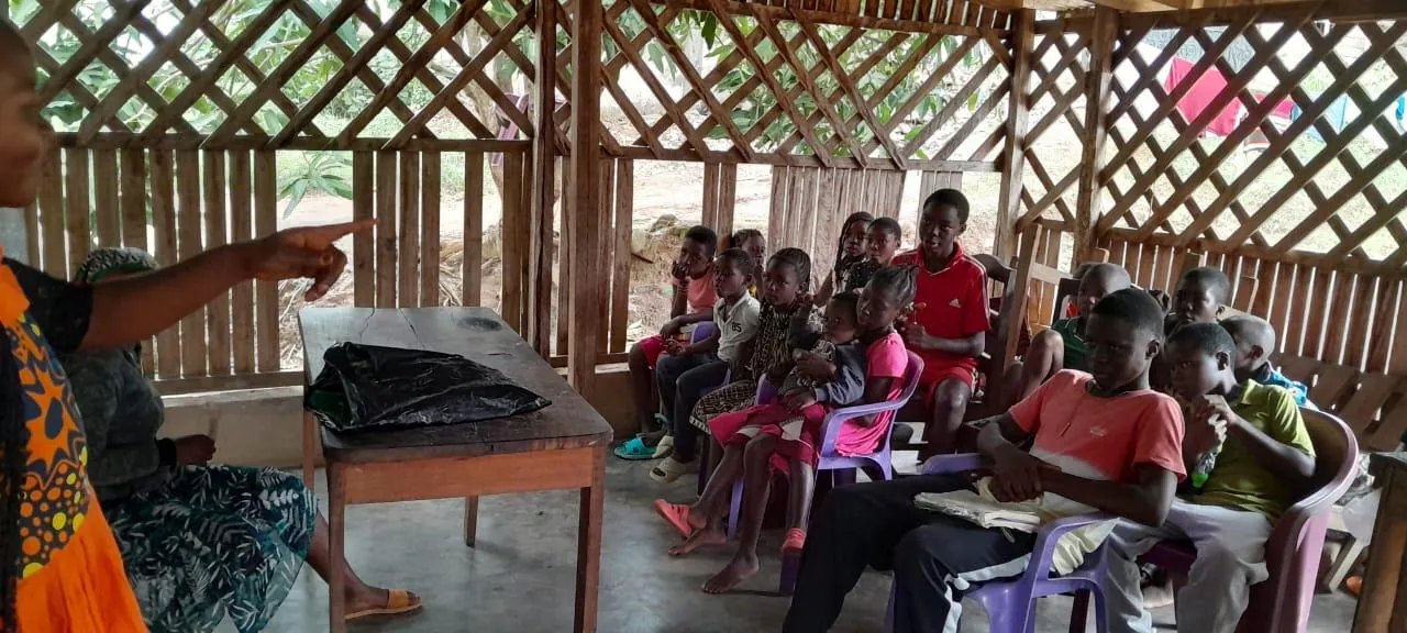 A teacher leading children in an open-air Bible class