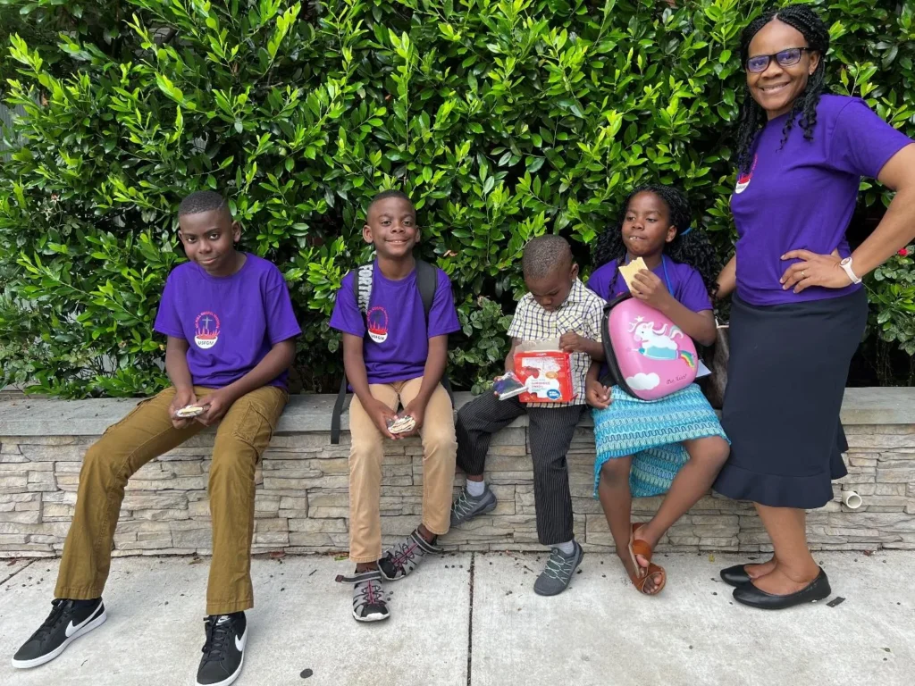 A ministry worker with children in purple shirts