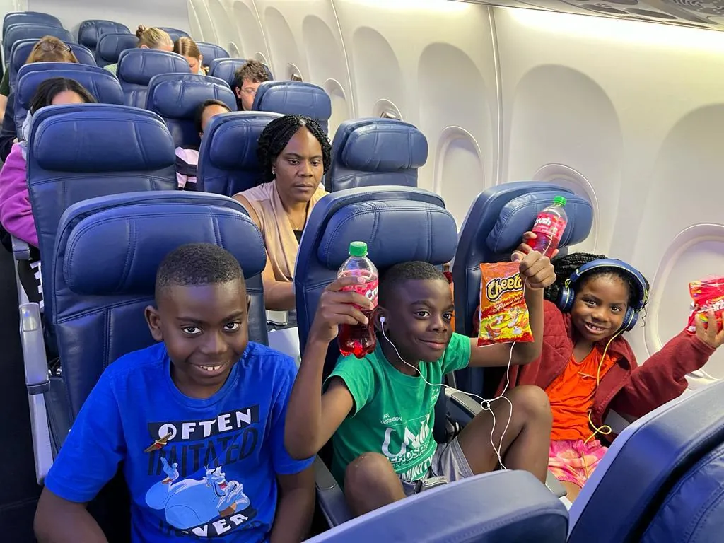 Children smiling together on a ministry trip flight